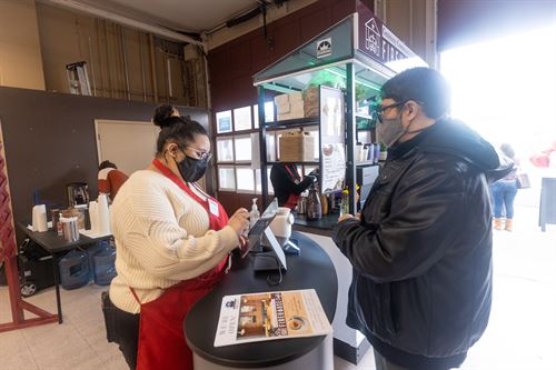 Worker at Firehouse Cafe serving customer